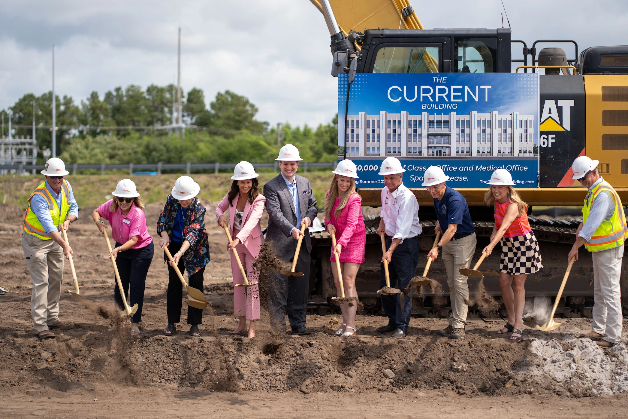 Groundbreaking ceremony with principals and ceremonial shovels at The CURRENT Building site