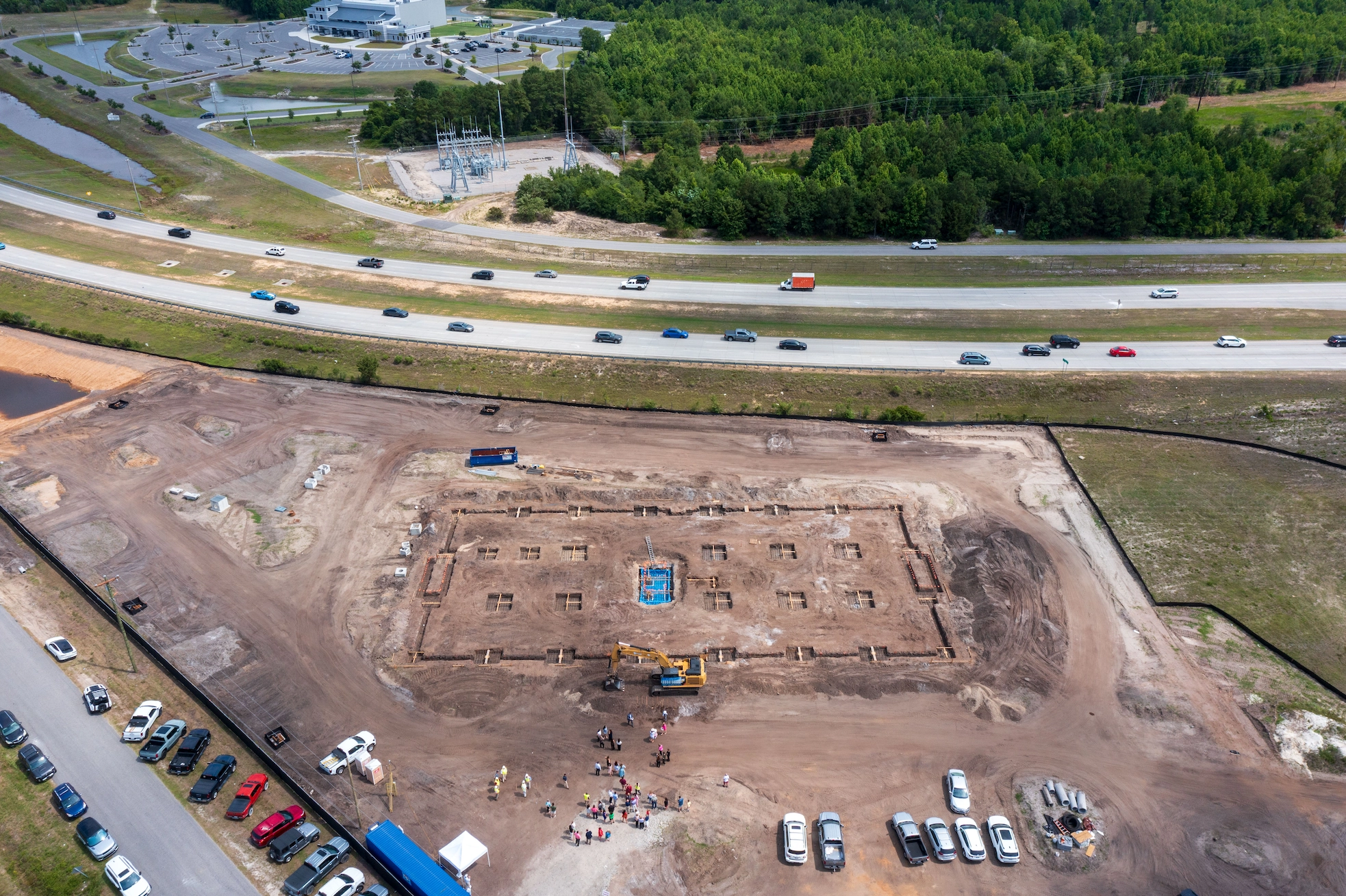 Wide aerial overview of The CURRENT Building construction site and foundation layout